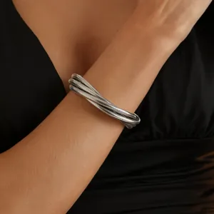 Silver multi-layer snake bone bracelet worn on arm, showing metallic texture and detail