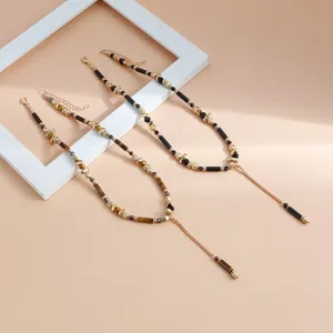 Nahaufnahme von böhmischen Y-Halsketten mit Tigerauge-Perlen und goldenen Metallakzenten