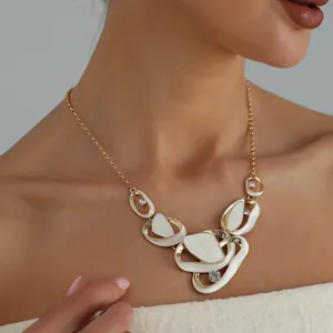 Detailed close-up of French pleated hollow pendant necklace with white enamel and stones