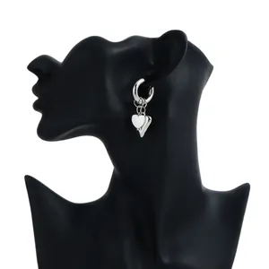 Close-up view of a silver heart charm hoop earring on a black display bust.