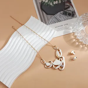 Detail of French style hollow white pendant necklace and earring set on white display
