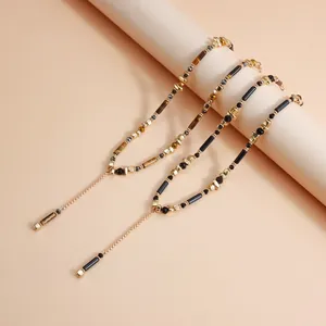Detail der böhmischen Y-Kette mit Tigerauge und schwarzen Perlen auf Goldkette.