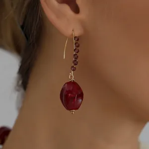 Detailed macro view of a vintage red acrylic bead drop earring worn on model's ear