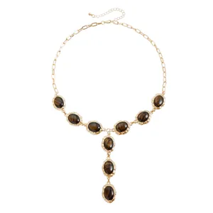 Collana a Y in oro vintage con pietre ovali occhio di tigre e bordi metallici lavorati.