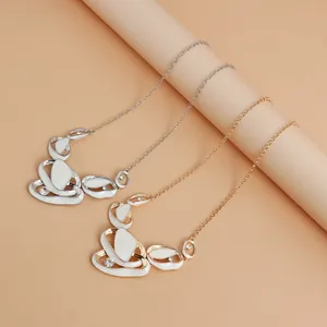 Detail view of French pleated hollow-out necklaces with white enamel and sparkling rhinestones
