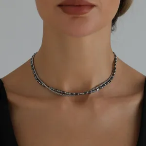 Dettaglio di una collana minimalista a due strati con ematite nera e perle d'argento.