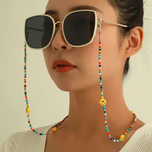 Detail shot of a colorful beaded eyeglass chain with smiley face charms on a model