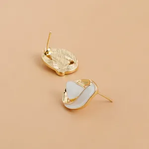 Elegant gold-tone stud earrings with white inlay in a French vintage organic shape.