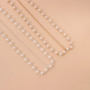 Detailed view of handmade pearl hairbands with gold and silver chain accents.