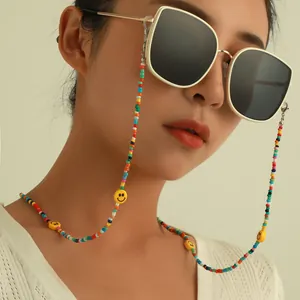 Close-up detail of colorful beaded glasses chain with cute yellow smiley face charms.