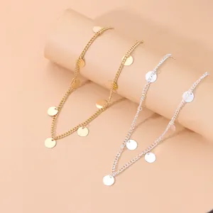 Close-up of gold and silver metallic sequin tassel chain headbands on a display prop