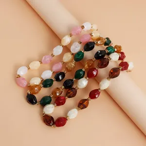 Close-up of retro mixed color acrylic beaded necklaces on a beige studio background.