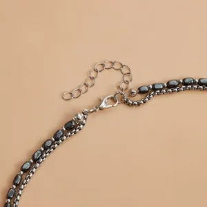 Dettaglio di una collana a doppio strato con perle di ematite e chiusura a moschettone