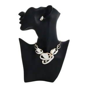 Detail view of elegant French style gold and white enamel necklace set on black mannequin