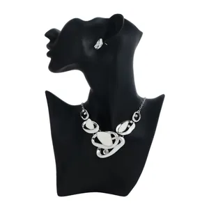 Detail view of silver-toned French-style hollowed pendant necklace and earring set on mannequin.