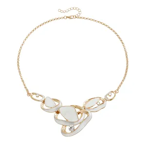 Elegant gold-tone necklace featuring white enamel abstract pendants and rhinestone accents