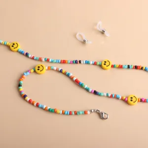 Close-up detail of a colorful beaded eyeglass chain with yellow smiley faces and a clasp.