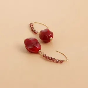 Detailed view of vintage red acrylic drop earrings with gold-wrapped purple beads.