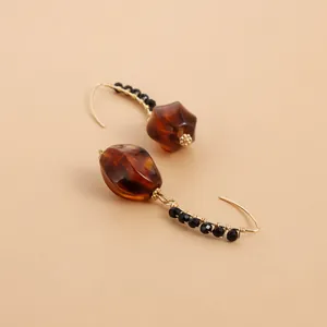 Vintage amber acrylic dangle earrings featuring black bead detailing on golden hooks