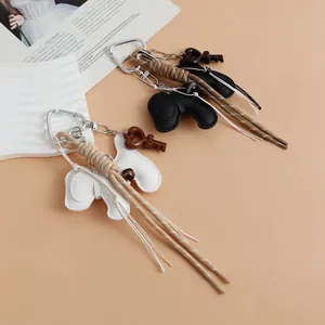 Detailed view of woven puppy keychains with heart charms and leather pendants for bags