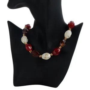 Detail view of a retro acrylic color-block beaded necklace with chunky red and cream beads