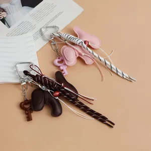 Detail shot of cute puppy leather keychains featuring braided rope and key charms.