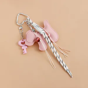 Detail view of pink puppy leather keychain with woven ribbons and heart charm