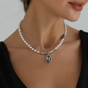 Primer plano de collar de perlas barrocas con barra plateada y colgante gris oscuro