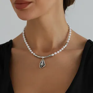 Elegante collar de perlas barrocas con colgante de cristal oscuro en el cuello de modelo