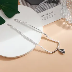 Primer plano de collar de perlas barrocas con colgante de gema negra en estilo minimalista