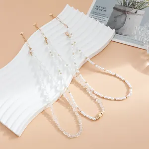 Primer plano de collares de perlas barrocas y cristal en un soporte elegante.