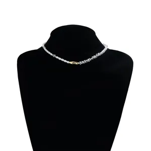 Primer plano de un collar artesanal de perlas barrocas y cristales sobre un busto negro