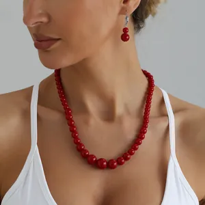 Elegant red beaded necklace and earring set showcased on a model wearing a white top