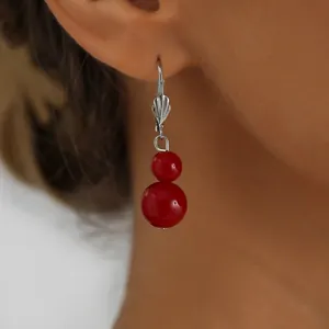 Detailed close-up of elegant double red bead drop earrings with silver hooks on model.