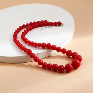 Detailed macro view of a fashionable red gradient beaded necklace with glossy finish