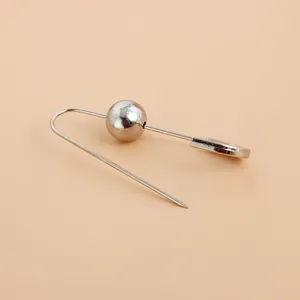 Détail d'une broche épingle à nourrice argentée minimaliste avec une sphère polie.
