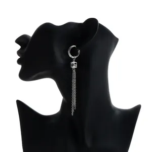 Detailed view of silver hoop earring with floral ceramic bead and long tassels