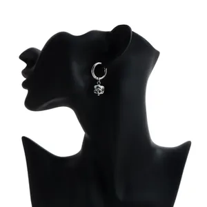 Detailed side view of silver hoop earring with floral pattern ceramic pendant