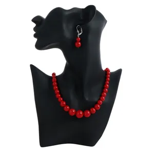 Elegant red round beaded necklace and earring jewelry set on a black mannequin bust