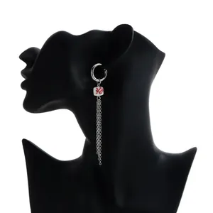 Close-up view of silver tassel earring featuring a red floral print ceramic cube on mannequin.