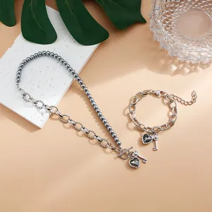 Elegante conjunto de joyas con corazón y llave, perlas grises y piedras negras