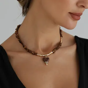Detailed view of Maillard brown beaded necklace with a golden lava heart pendant.