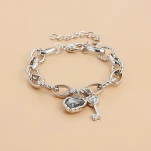 Pulsera de cadena plateada con piedra gris en forma de corazón y dije de llave de corazón