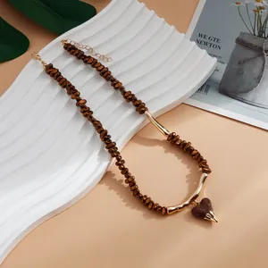 Close-up of Maillard brown beaded necklace with a glossy lava heart pendant detail