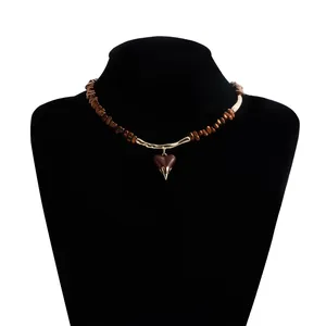 Detail shot of a brown beaded lava heart pendant necklace on a black mannequin