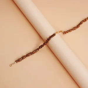 Close-up of golden lava heart clasp on Maillard brown beaded necklace detail view