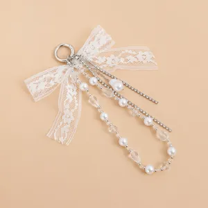Llavero elegante con lazo de encaje, perlas blancas, cristales y cadenas de diamantes