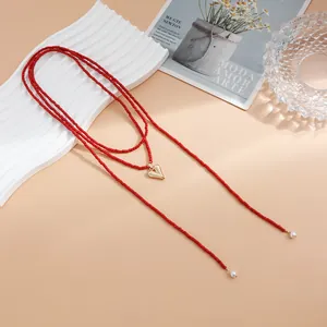 Long red seed bead necklace with gold heart pendant and pearl details