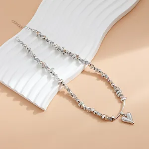 Détail du pendentif cœur argenté et de la chaîne de collier en perles de cristal