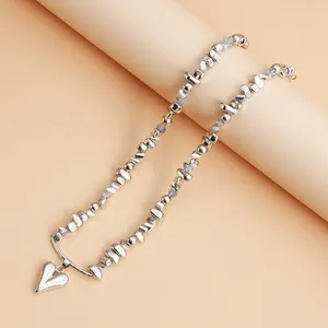 Gros plan détaillé d'un collier de perles argentées avec pendentif en forme de cœur